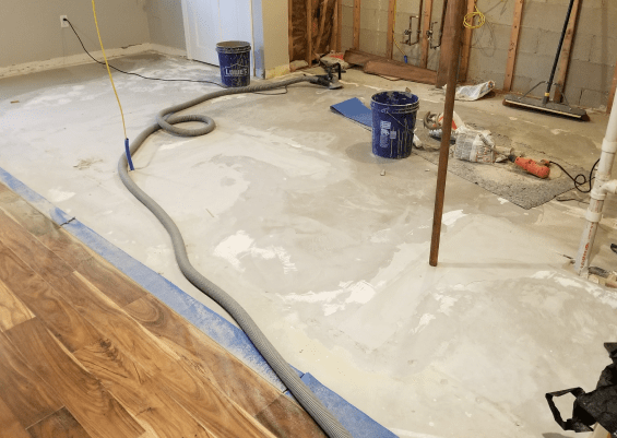 A picture of during subflooring process with cement and tools used in the process.